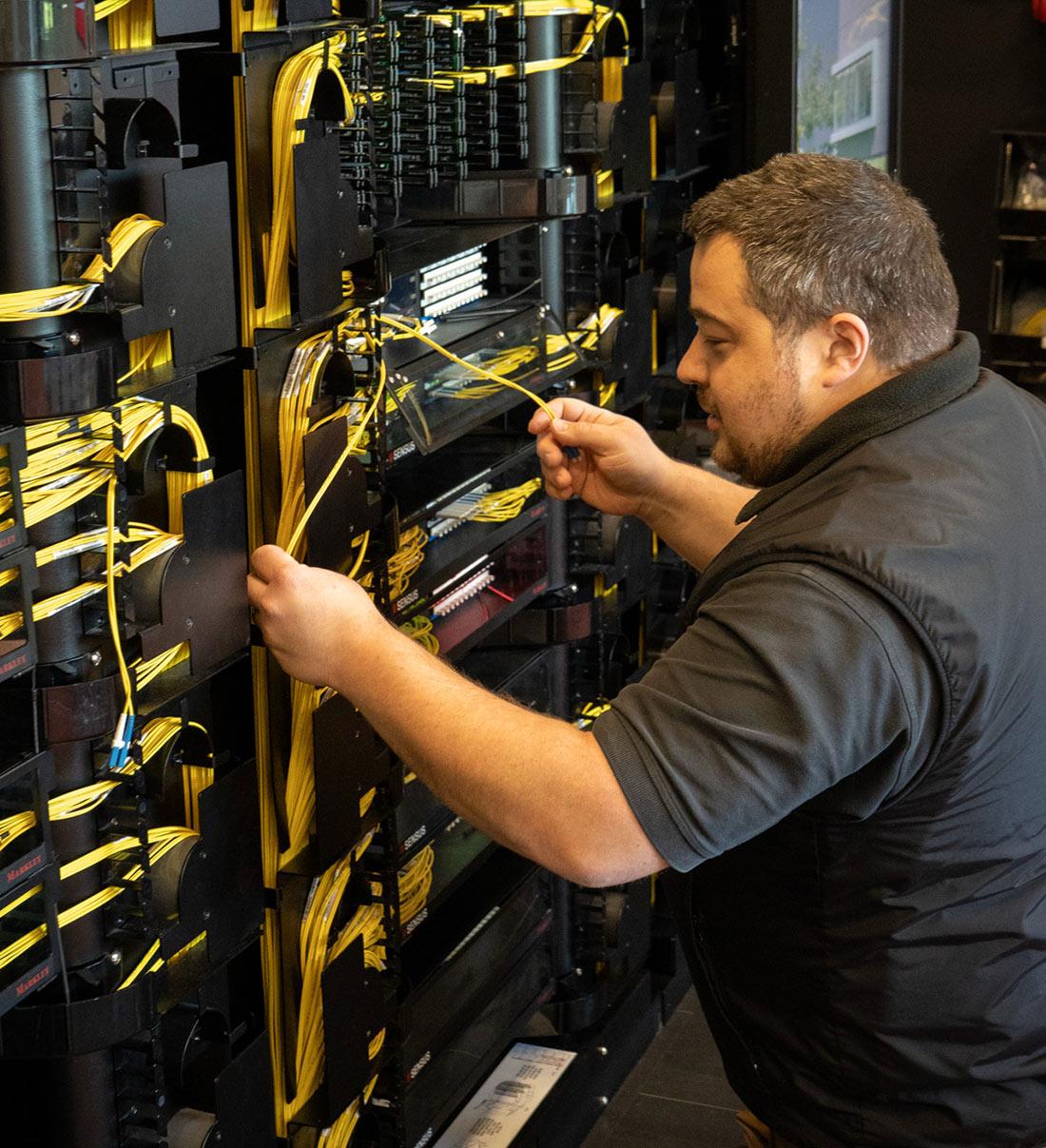 A smiling Markley data center technician in the server hall